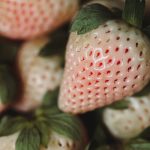 Pineberry or White Strawberry on Wooden Plate with Dark Background